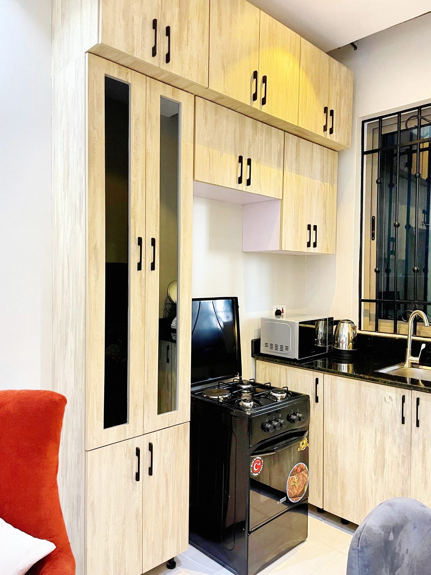 Fully fitted kitchen with cabinets, gas cooker and microwave at SN Suites Apartments